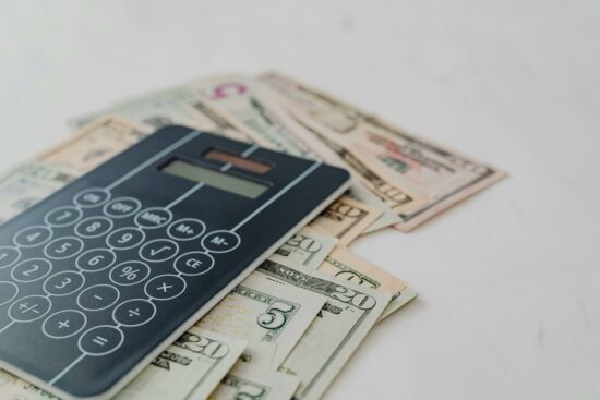 A solar calculator on top of some scattered dollar bills